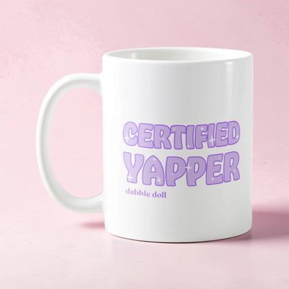 Dabble Doll Certified Yapper Coffee Mug Novelty with Playful Purple Text on a White Background