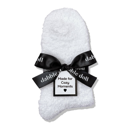 Dabble Doll Gift Box featuring cozy socks wrapped with a black bow for cozy moments