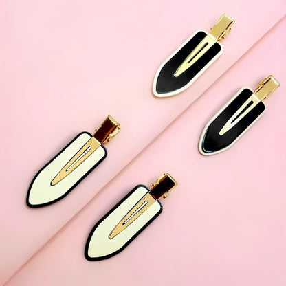 Dabble Doll crease free hair clips in black and white with gold accents on pink background