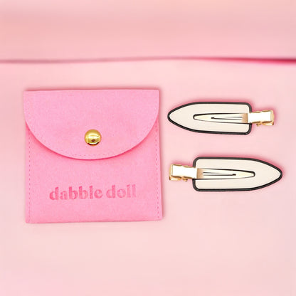 Dabble Doll creaseless clips for styling with black and white finish alongside pink carrying pouch