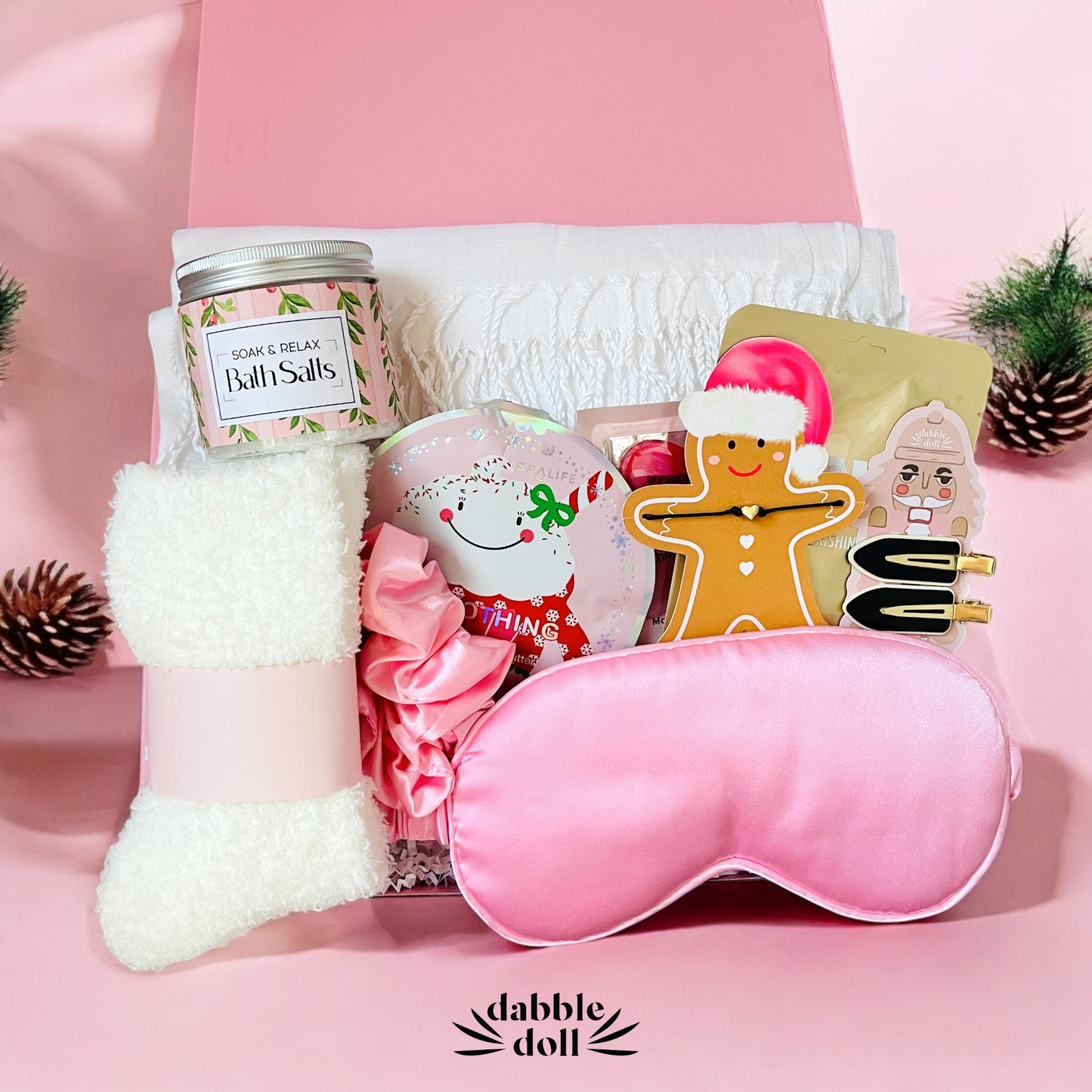 Pink gift box for girls featuring bath salts, cozy socks, sleep mask, and festive treats