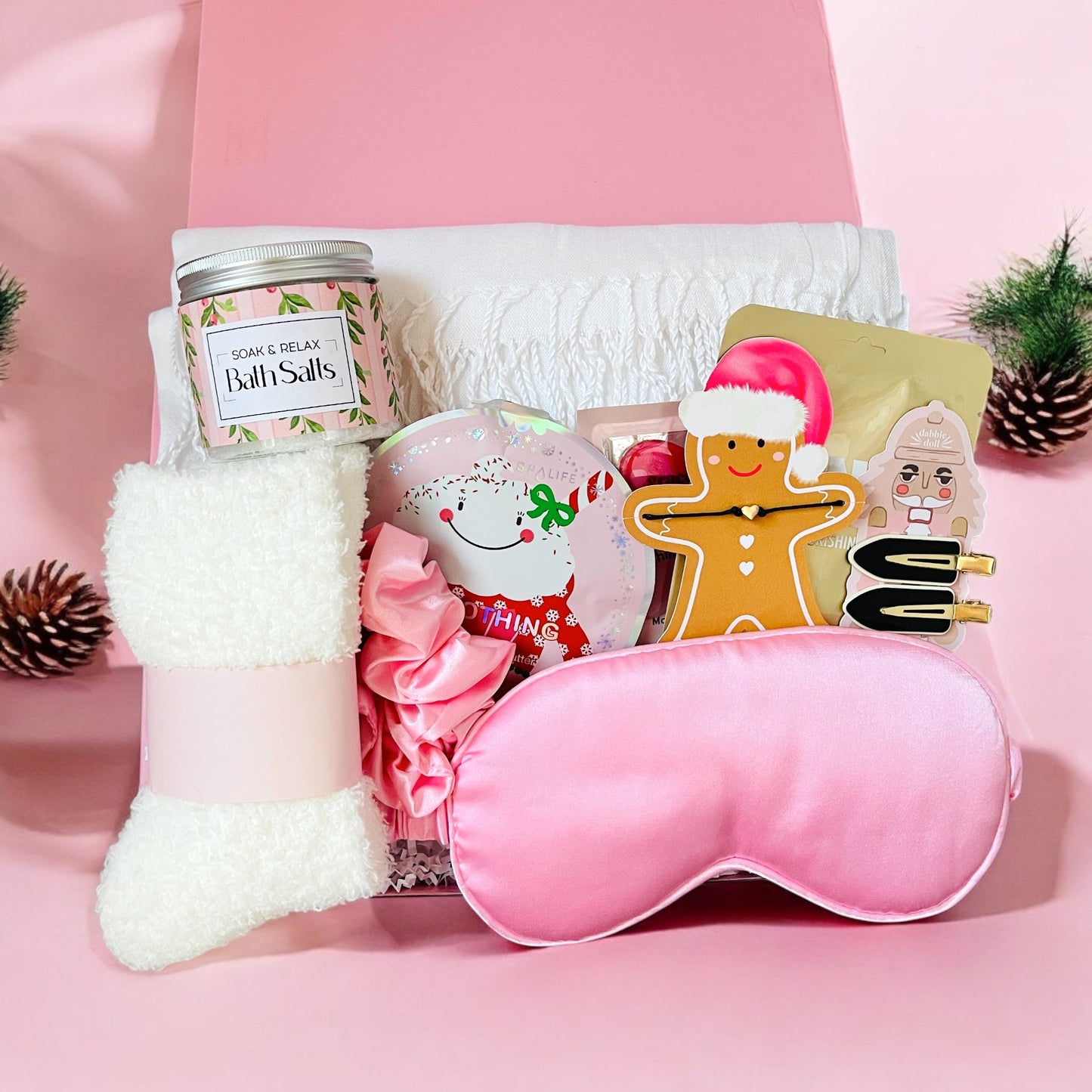 Dabble Doll Gift Box in pink featuring cozy socks, eye mask, and holiday-themed items for girls and women