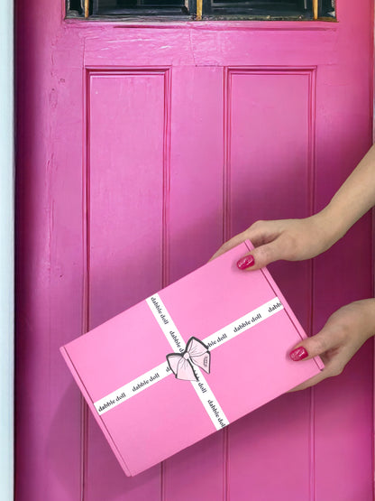 Pink gift box from Dabble Doll, perfect for girls and women, elegantly wrapped with a bow