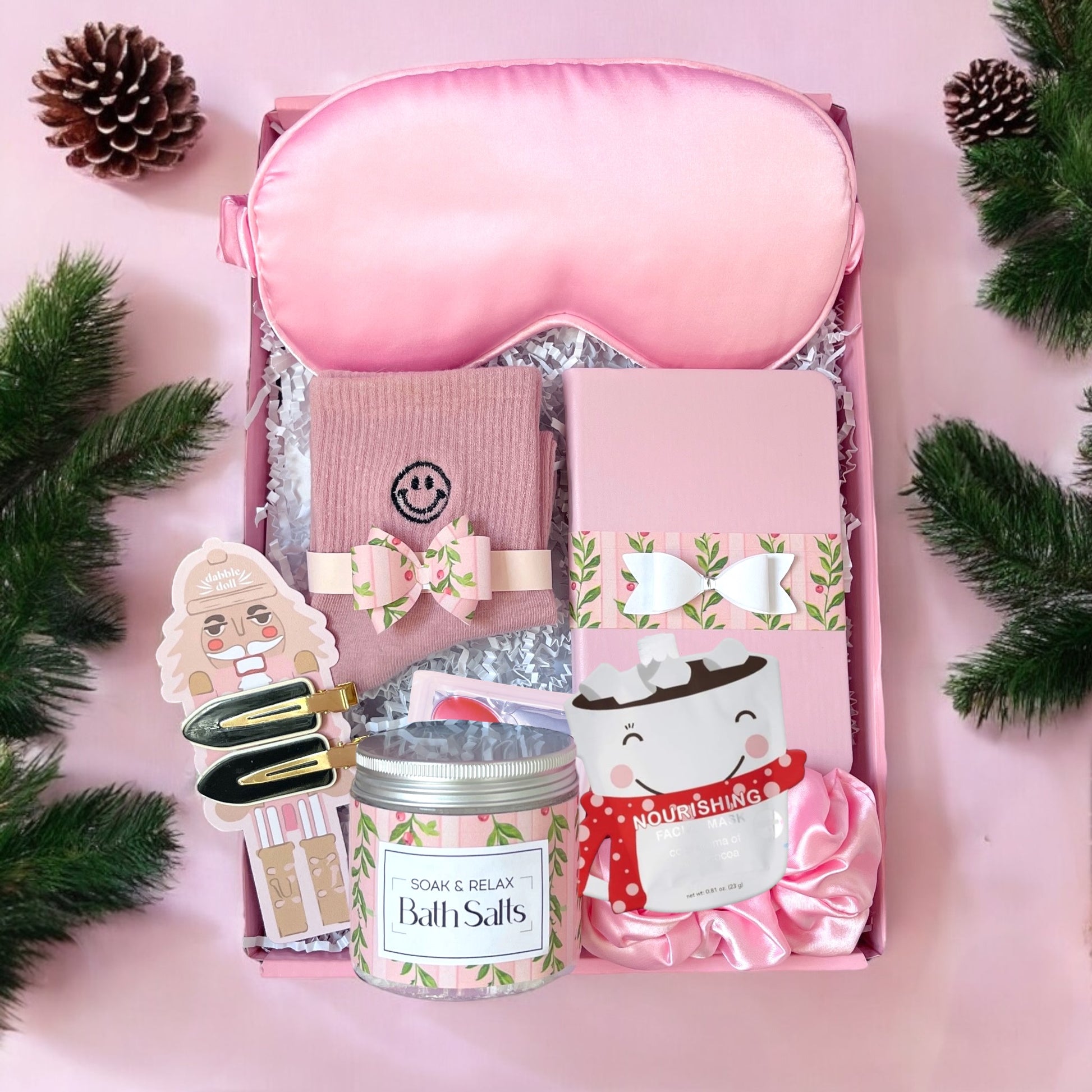 Dabble Doll pink gift box for women featuring bath salts, a sleep mask, and cozy accessories