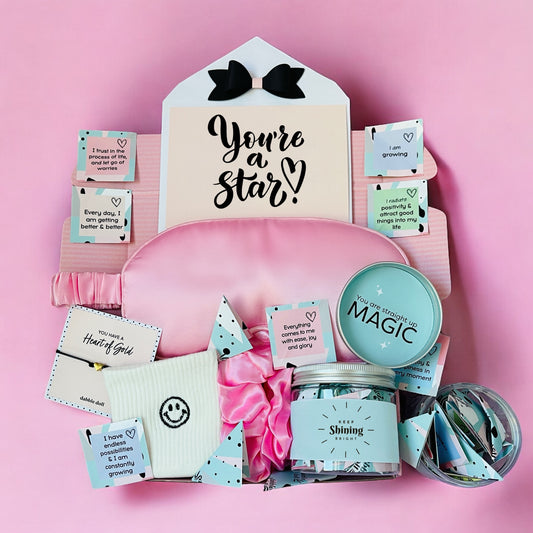 Dabble Doll Gift Box in pink featuring self-care items for girls and women with inspirational quotes
