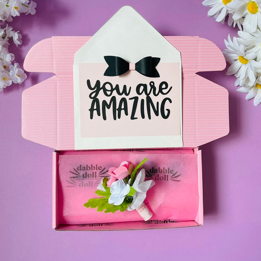 Dabble Doll gift in box featuring a floral arrangement and a card that says You Are Amazing