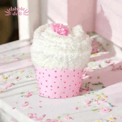 Dabble Doll gift in box resembling a cupcake with white frosting and a pink heart on top