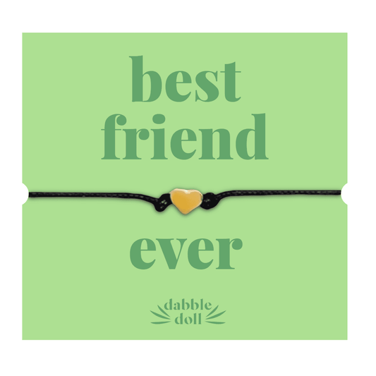 Dabble Doll gift featuring a black cord bracelet with a gold heart charm for best friends