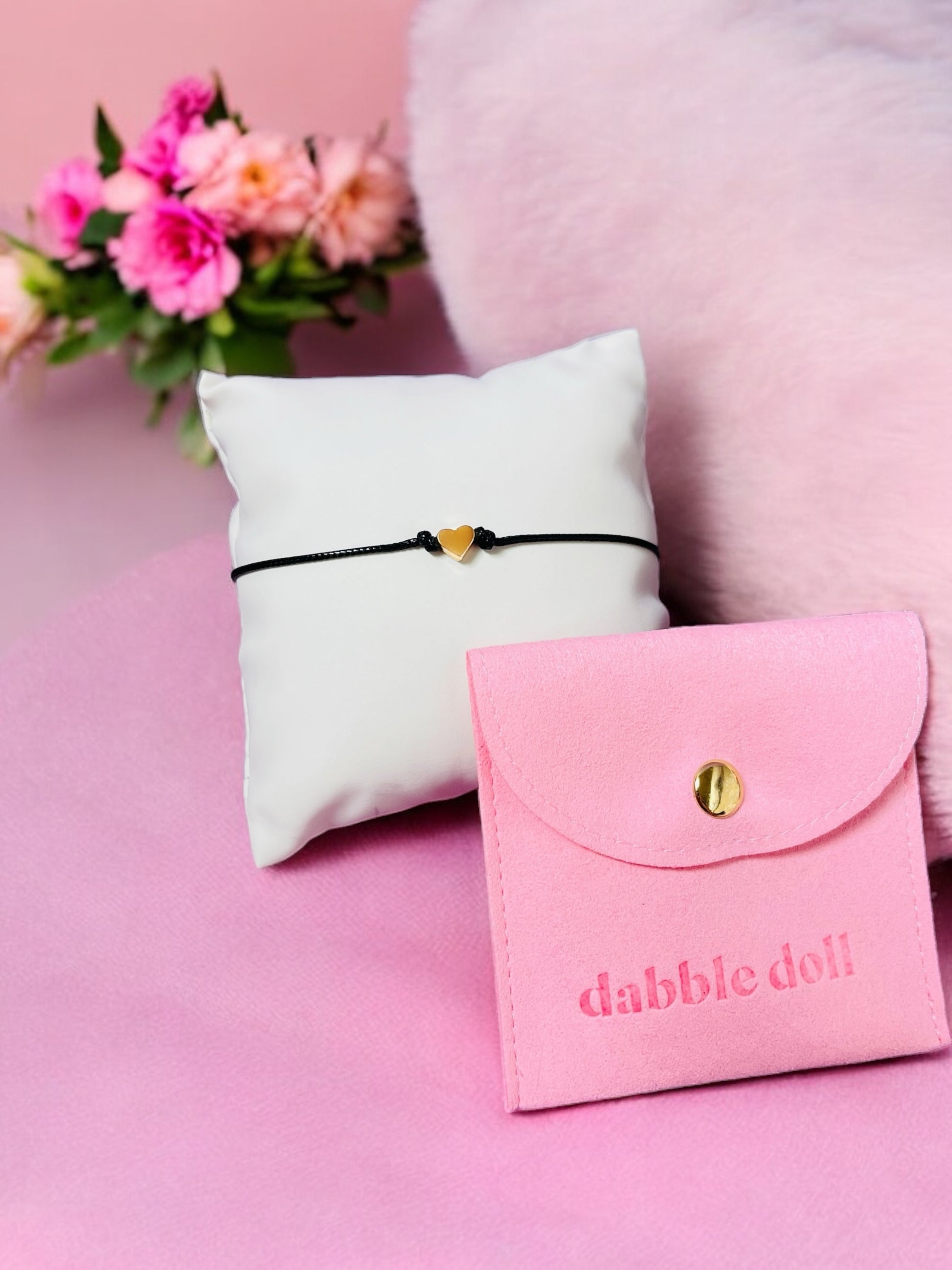 Gold heart bracelet on black cord with a pink felt pouch, perfect for girls and women