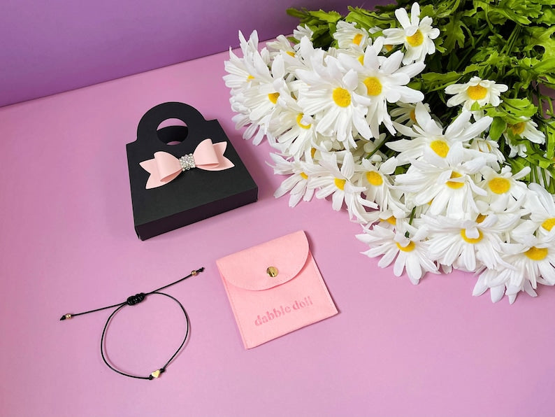 Dabble Doll black gift box with pink bow and gold heart bracelet for girls and women