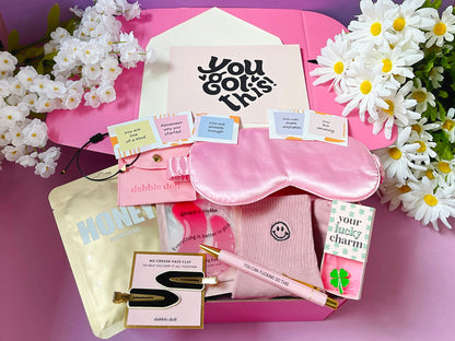 Dabble Doll good luck gift box with pink sleep mask, motivational cards, pen, honey mask, and lucky charm package