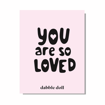Pink greeting card with bold black text saying 'You are so Loved' for girls and women from Dabble Doll