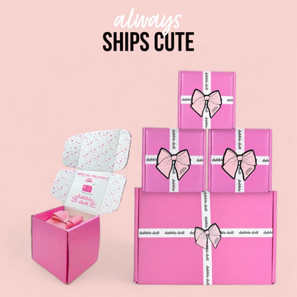 Dabble Doll pink gift boxes tied with ribbon featuring hot mess survival kit packaging