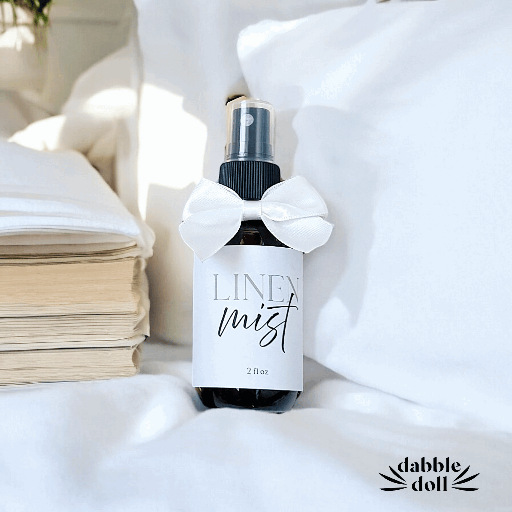 Dabble Doll Linen Mist in a 2 oz bottle with a white bow, perfect for women and girls for freshening up linens