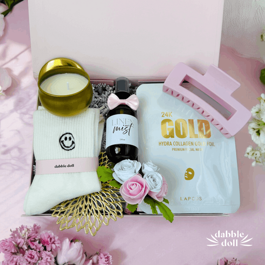 Dabble Doll luxury self care gift box with candle, socks, face mask, hair clip, and floral accents