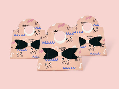 Set of three Dabble Doll mini purse favors in pink with black bows, perfect for girls and women