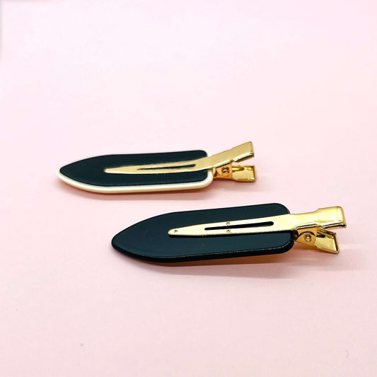 Dabble Doll black and gold no crease hair clips with sleek design on pink background
