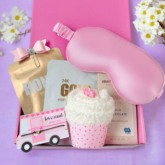 Pink spa gift box for her featuring a sleep mask, bath products, and a cupcake bath bomb