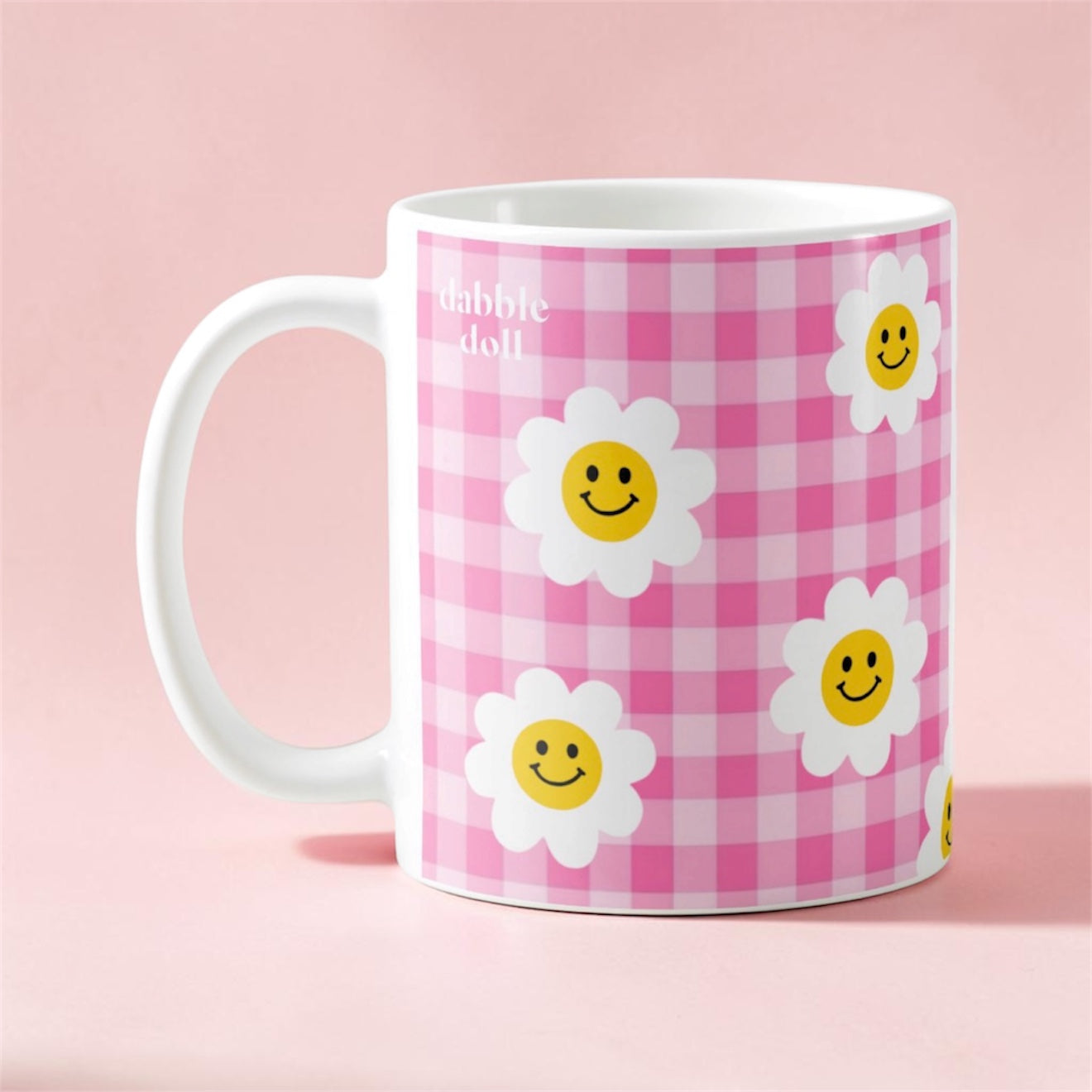 Dabble Doll smiley face mug with a pink checkered design and cheerful flower graphics