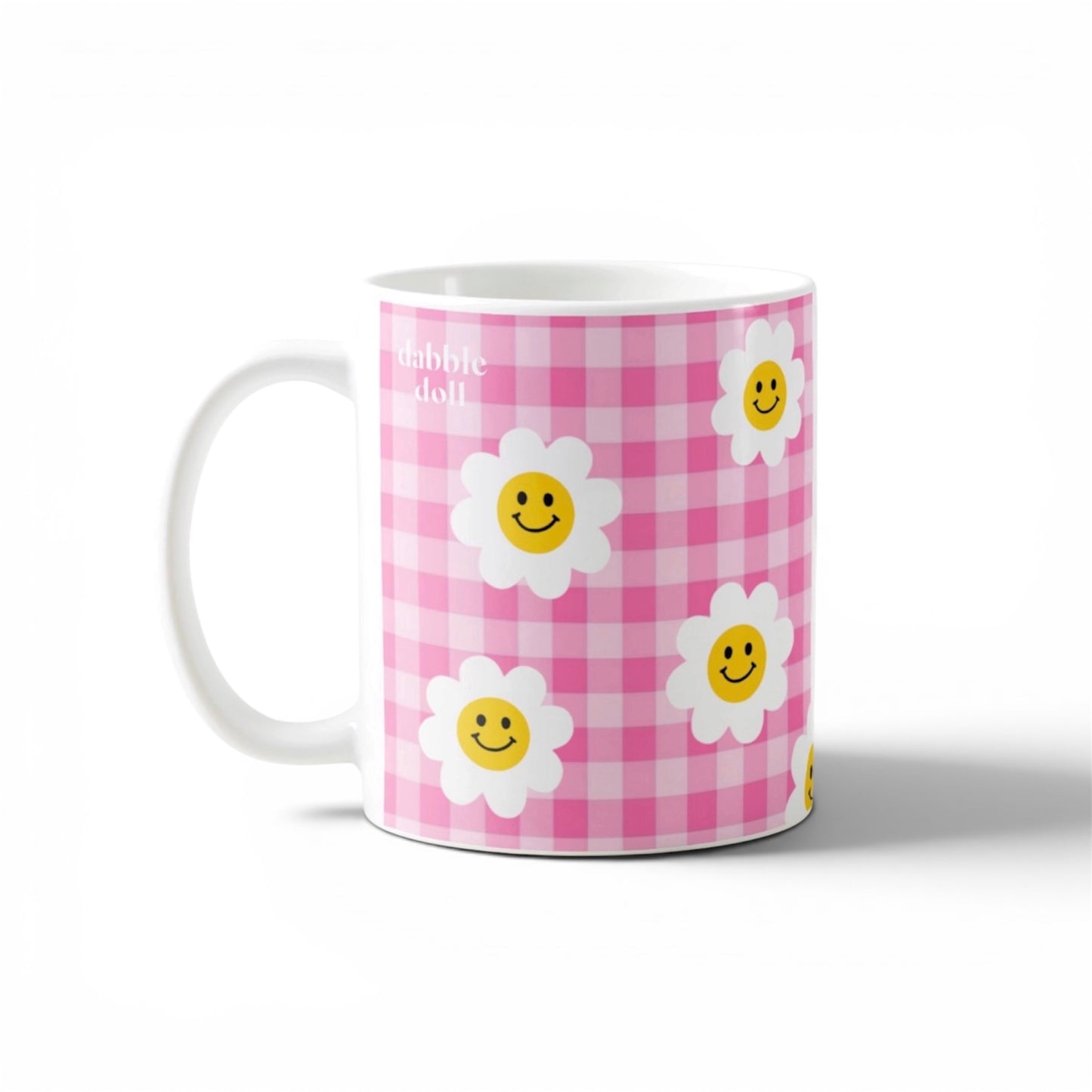 Dabble Doll smiley face mug featuring cheerful flowers and a pink gingham pattern