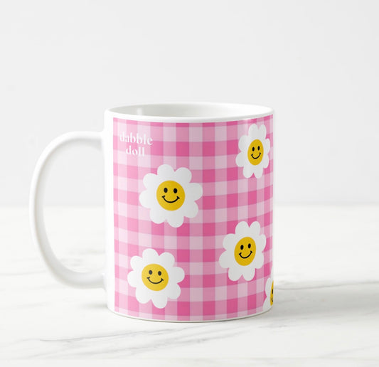 Dabble Doll pink checkered smiley face mug decorated with cheerful flowers and smiling faces