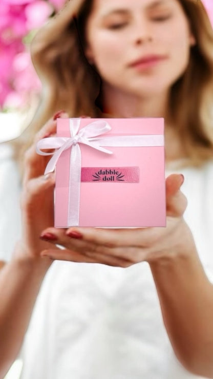 Dabble Doll gift box featuring cozy Socks wrapped in pink with a ribbon for stylish comfort
