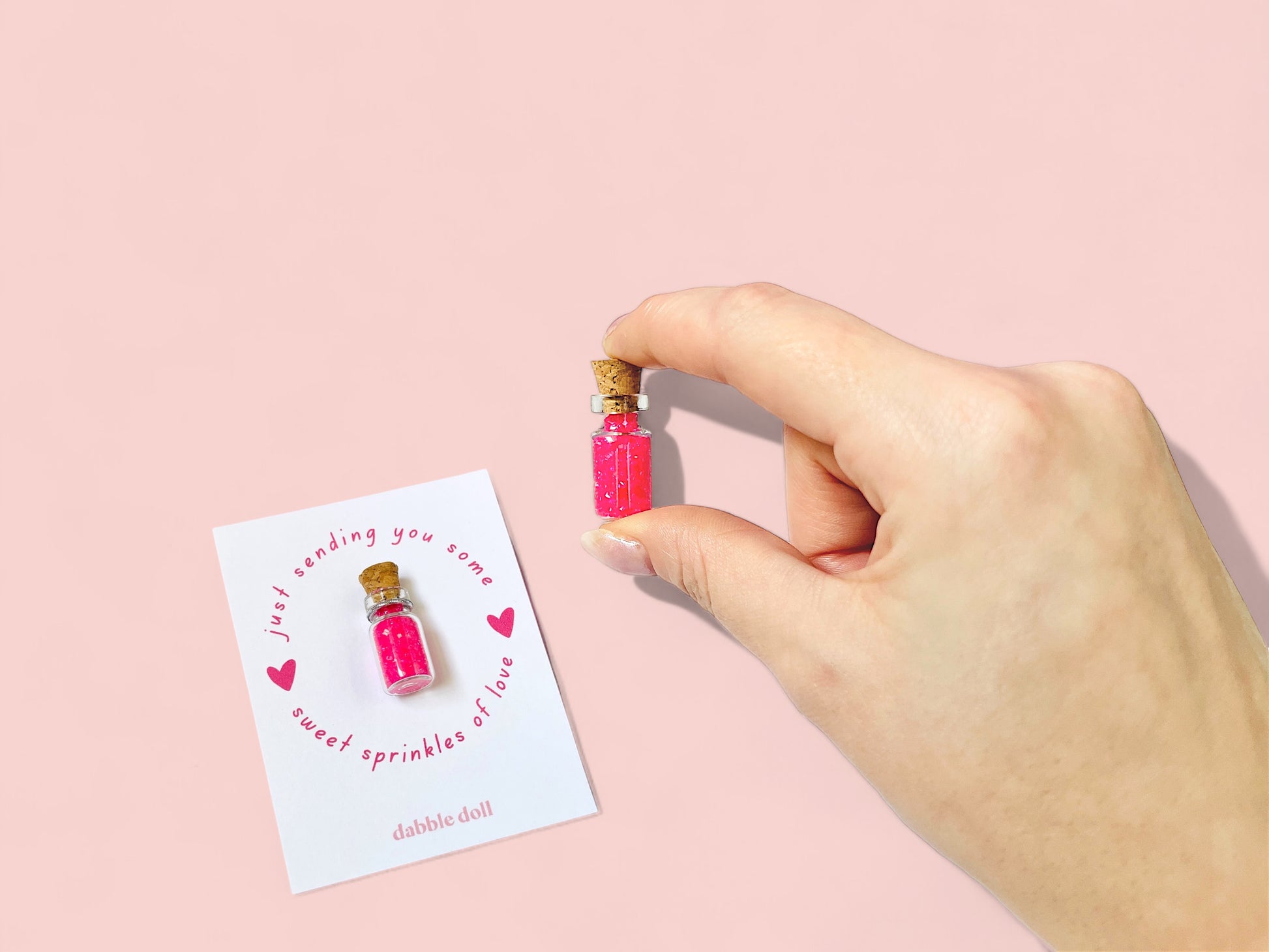 Mini glass bottle of pink sprinkles for girls by Dabble Doll, perfect for party favors or gifts