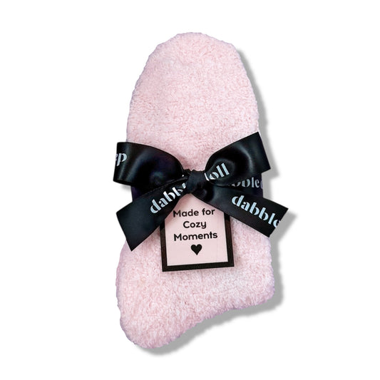 Dabble Doll Gift Box featuring fluffy socks tied with a black ribbon for cozy moments