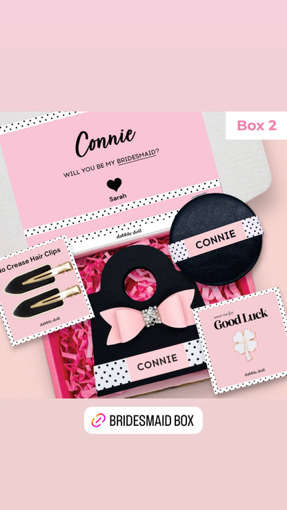 Dabble Doll Gift Box for girls featuring hair clips, a bracelet, and a motivational card in pink and black
