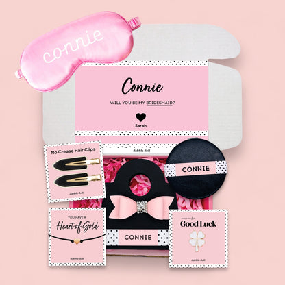 Dabble Doll gift box for girls containing a pink sleep mask, hair clips, and celebratory items