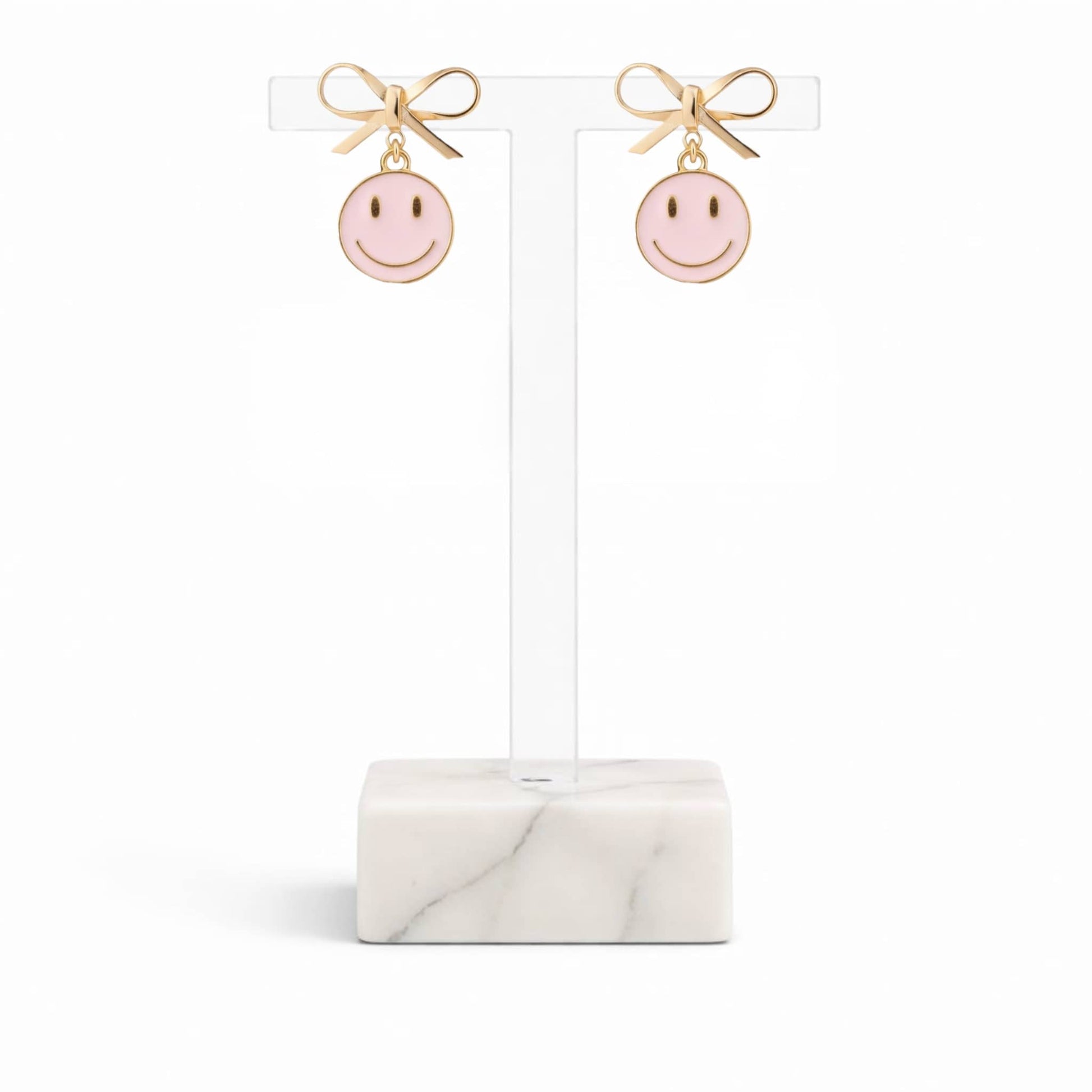 Dabble Doll pink smiley face earrings with gold bow accents for a cheerful accessory