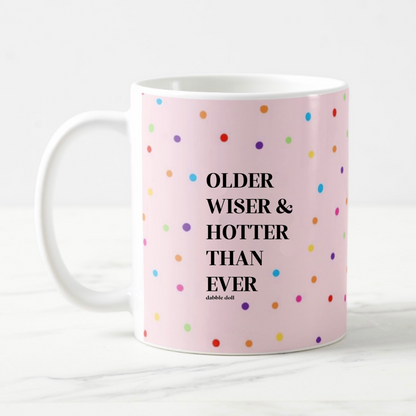 Funny coffee mug by Dabble Doll with colorful polka dots and the phrase Older Wiser & Hotter Than Ever