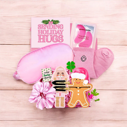Pink gift box for girls with holiday items including socks, a sleep mask, and a gingerbread decoration