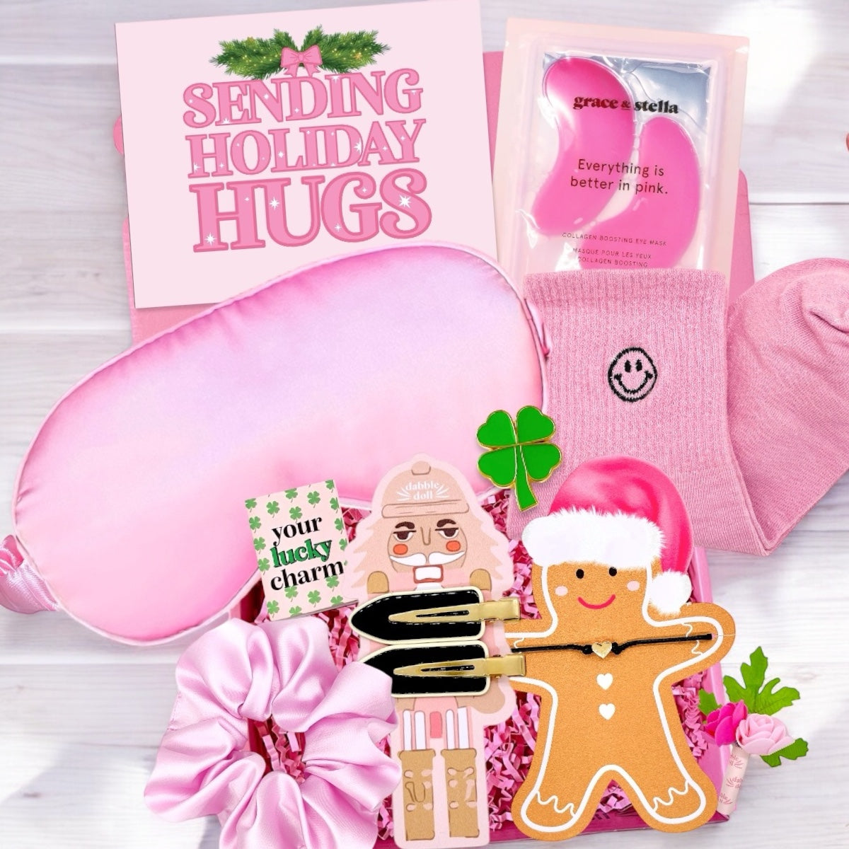 Pink gift box for girls and women featuring cozy sleep mask and fun holiday treats