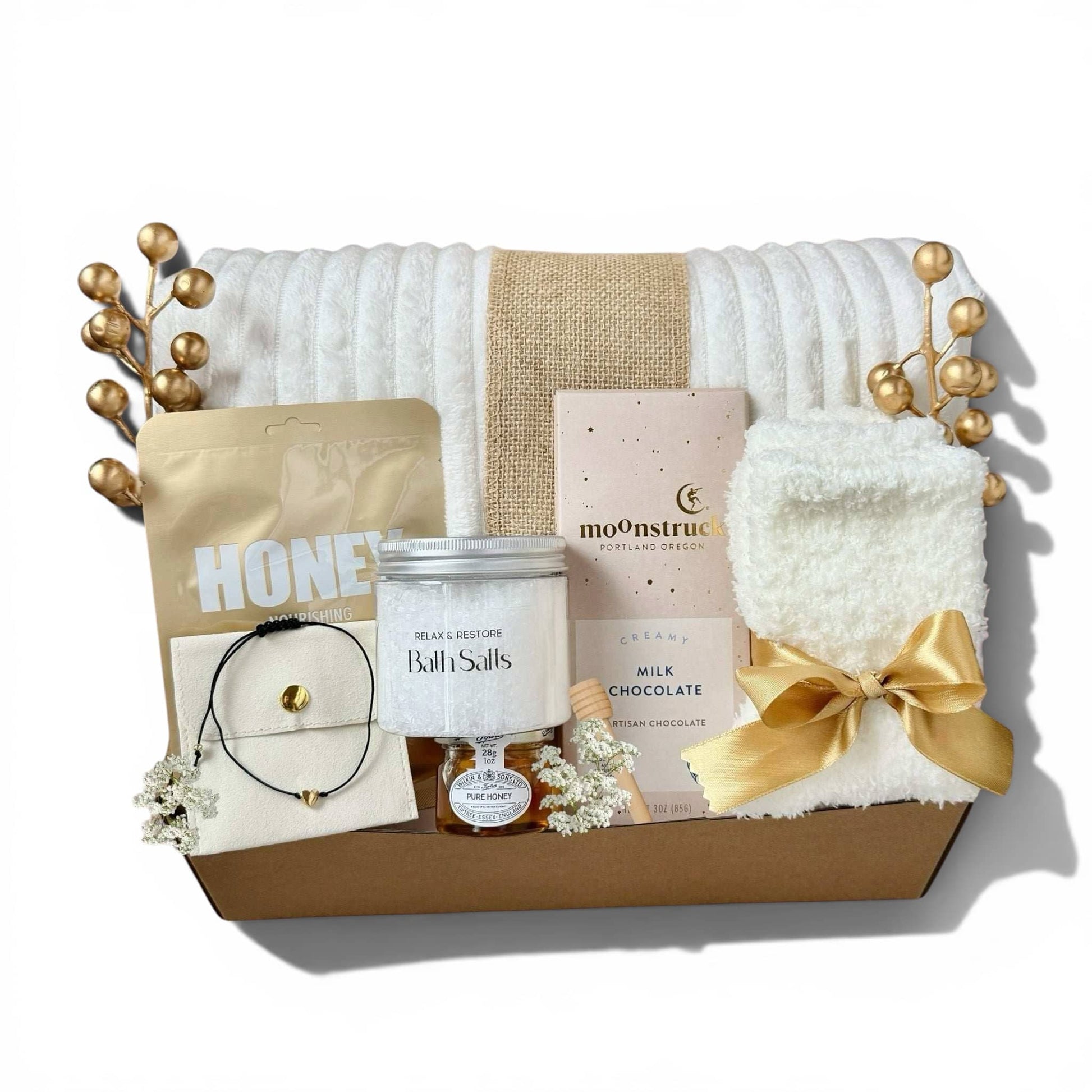 Elegant gift box for women featuring bath salts, chocolate, cozy accessories, and a soft blanket