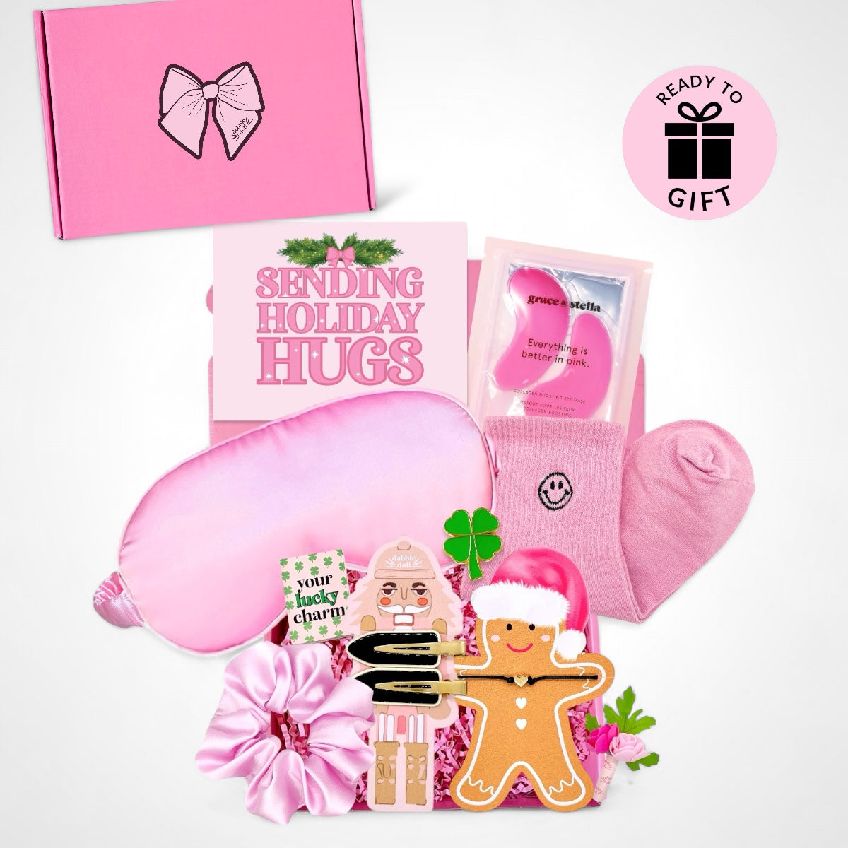 Pink Dabble Doll Gift Box for women with cozy socks, eye mask, and holiday-themed items