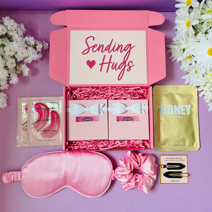 Pink Dabble Doll gift box for women featuring a sleep mask, hair scrunchie, and sweet treats