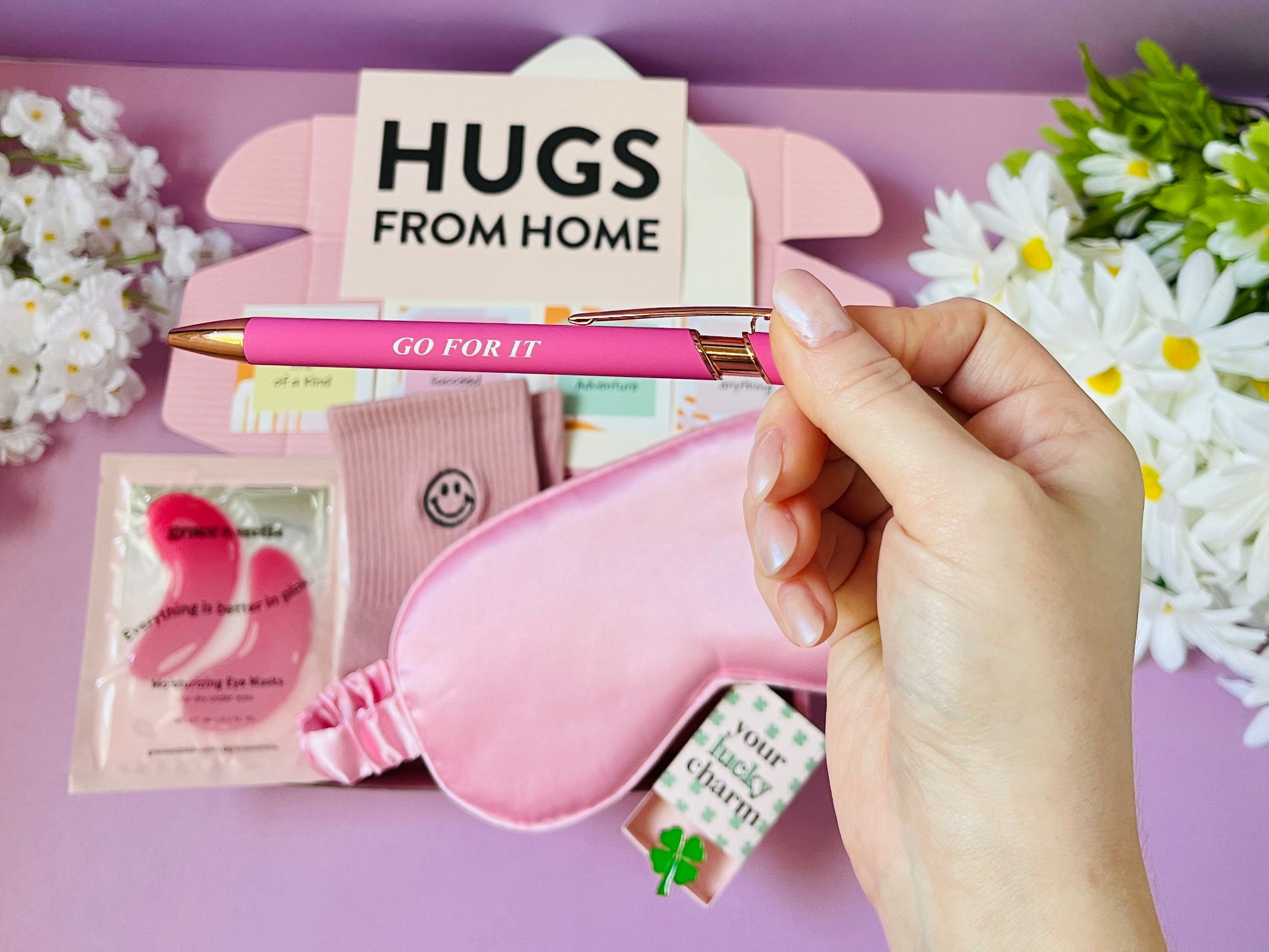 Pink themed hugs gift box from Dabble Doll with pen, sleep mask, socks, eye patches, and good luck charm