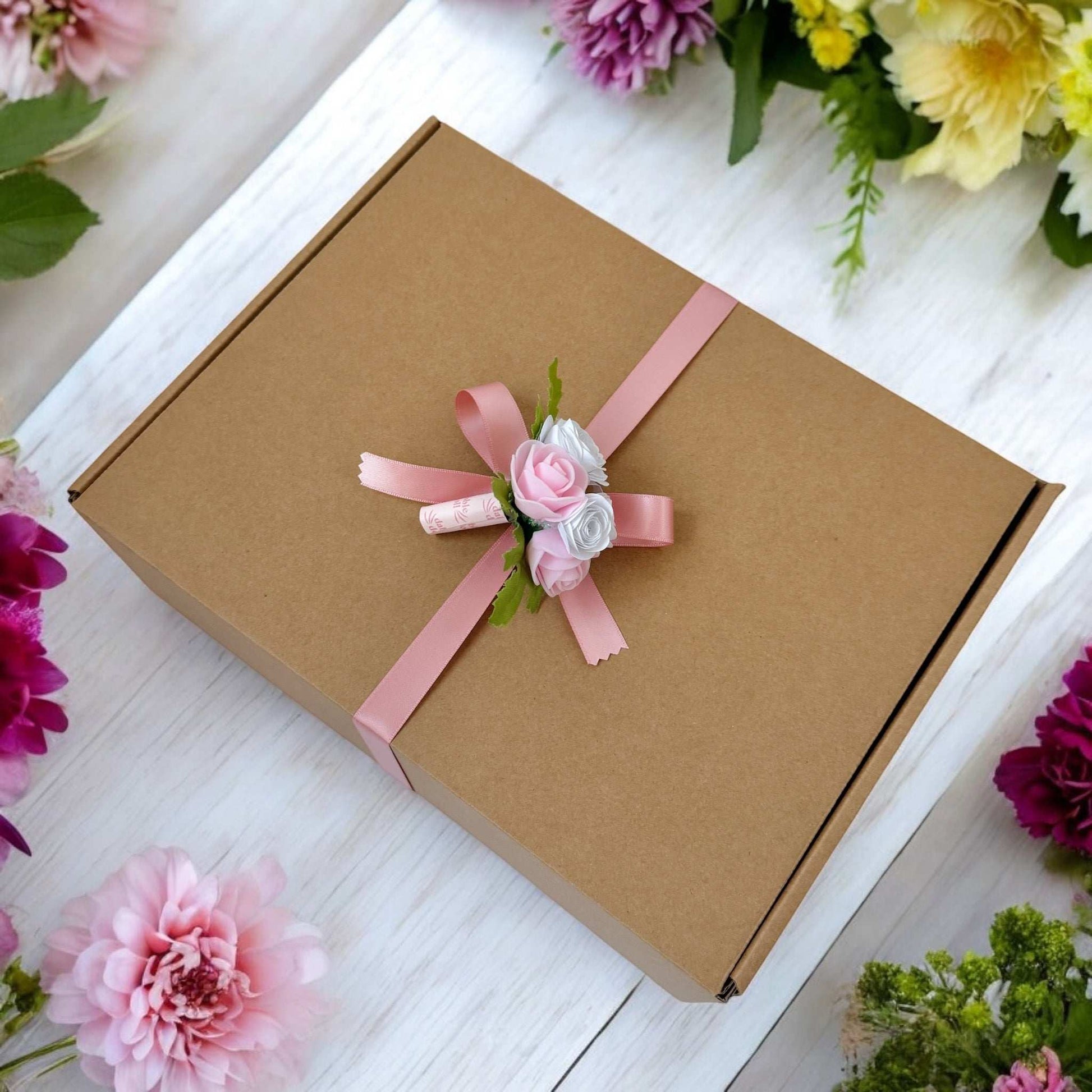 Dabble Doll hygge gift box wrapped in brown paper with pink ribbon and floral decoration