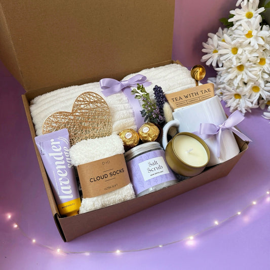 Dabble Doll Gift Box with lavender items including socks, salt scrub, candle, and tea for relaxation