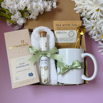 Dabble Doll gift in box featuring milk chocolate, a mug, tea, and a decorative spoon