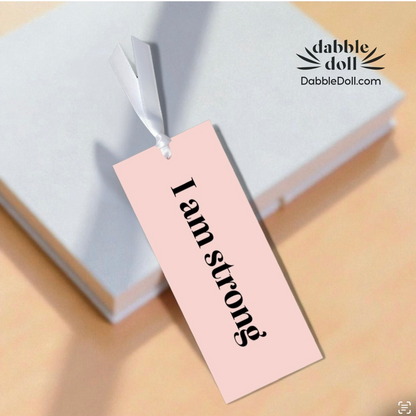 Dabble Doll motivational bookmark with the phrase I am strong hanging from a gift box
