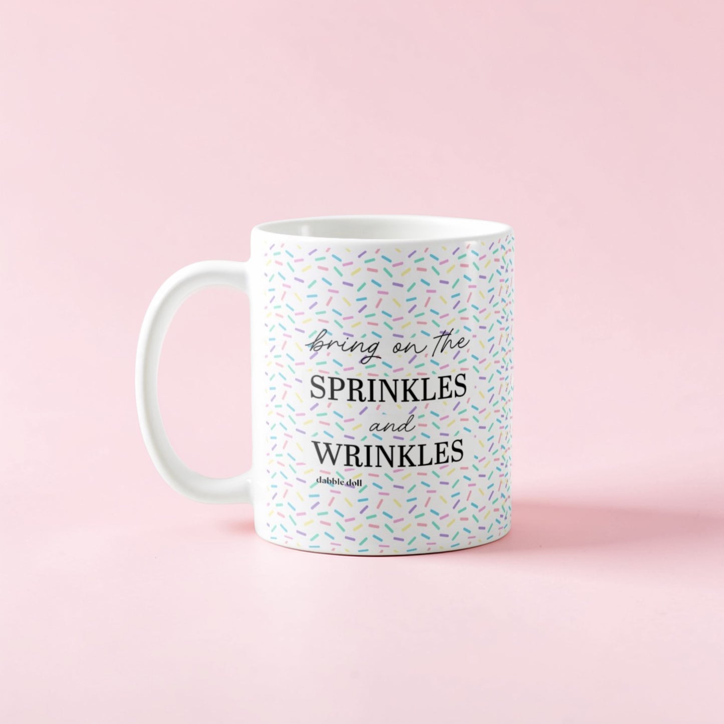 Dabble Doll coffee mug with colorful sprinkles design and the phrase Bring on the sprinkles and wrinkles