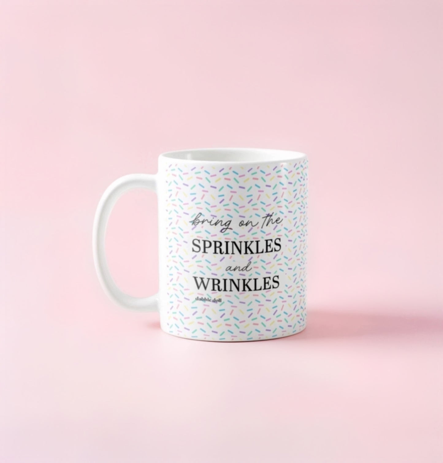 Dabble Doll coffee mug with colorful sprinkles design and the text Bring on the Sprinkles and Wrinkles