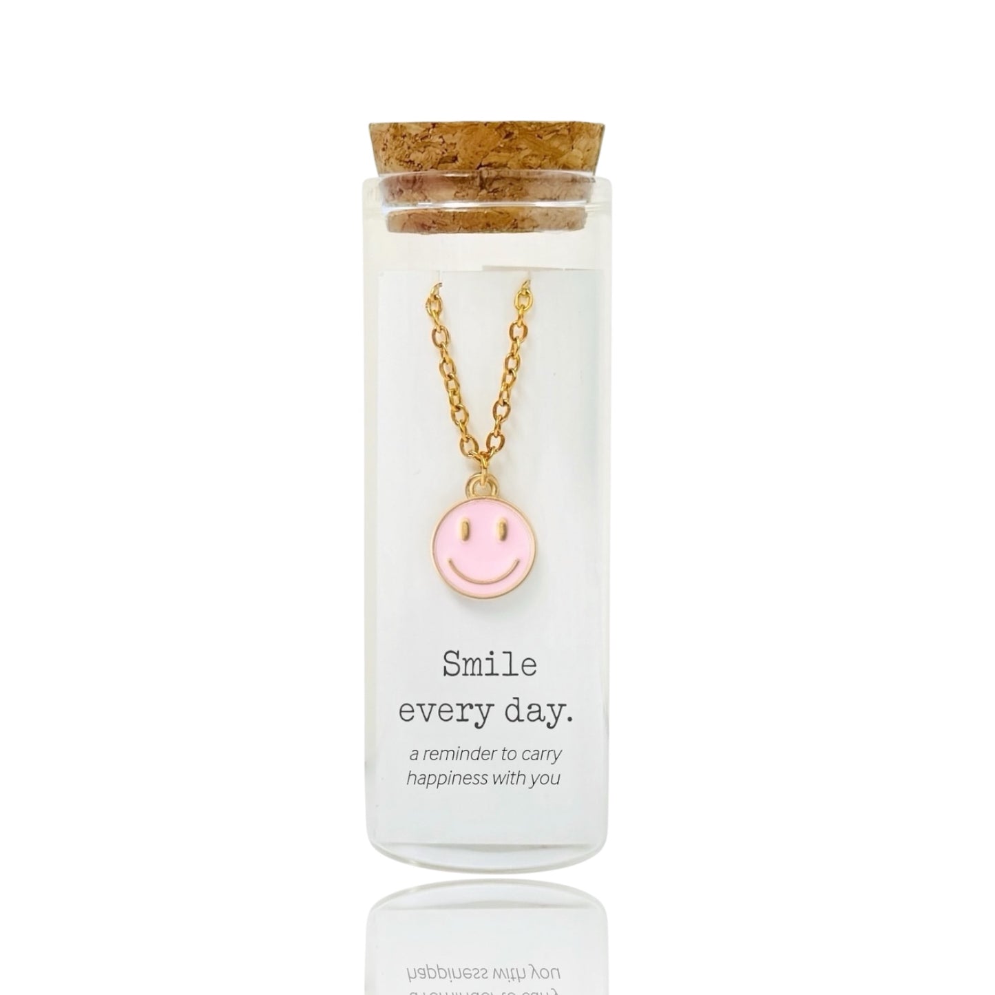 Gold necklace with a pink smiley face pendant in a glass bottle by Dabble Doll