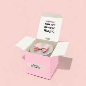 Dabble Doll pink gift box containing a personalized gift for girls with a lovely bow and uplifting message