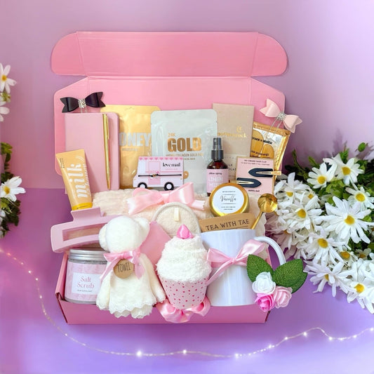 Pink gift box for women containing beauty products, self-care items, and a cupcake plushie