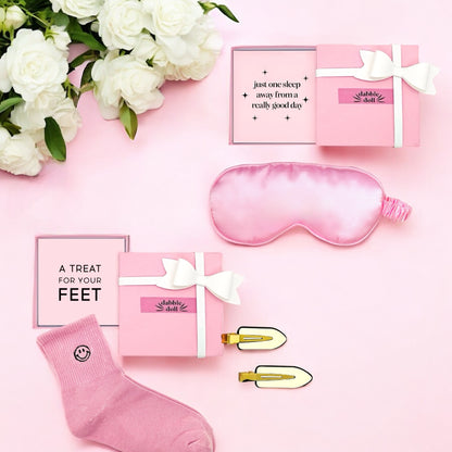 Pink sleep gift set for girls featuring a silk eye mask, cozy socks, and stylish clips