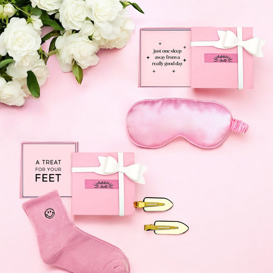 Pink sleep gift set for girls featuring a silk eye mask, cozy socks, and stylish clips