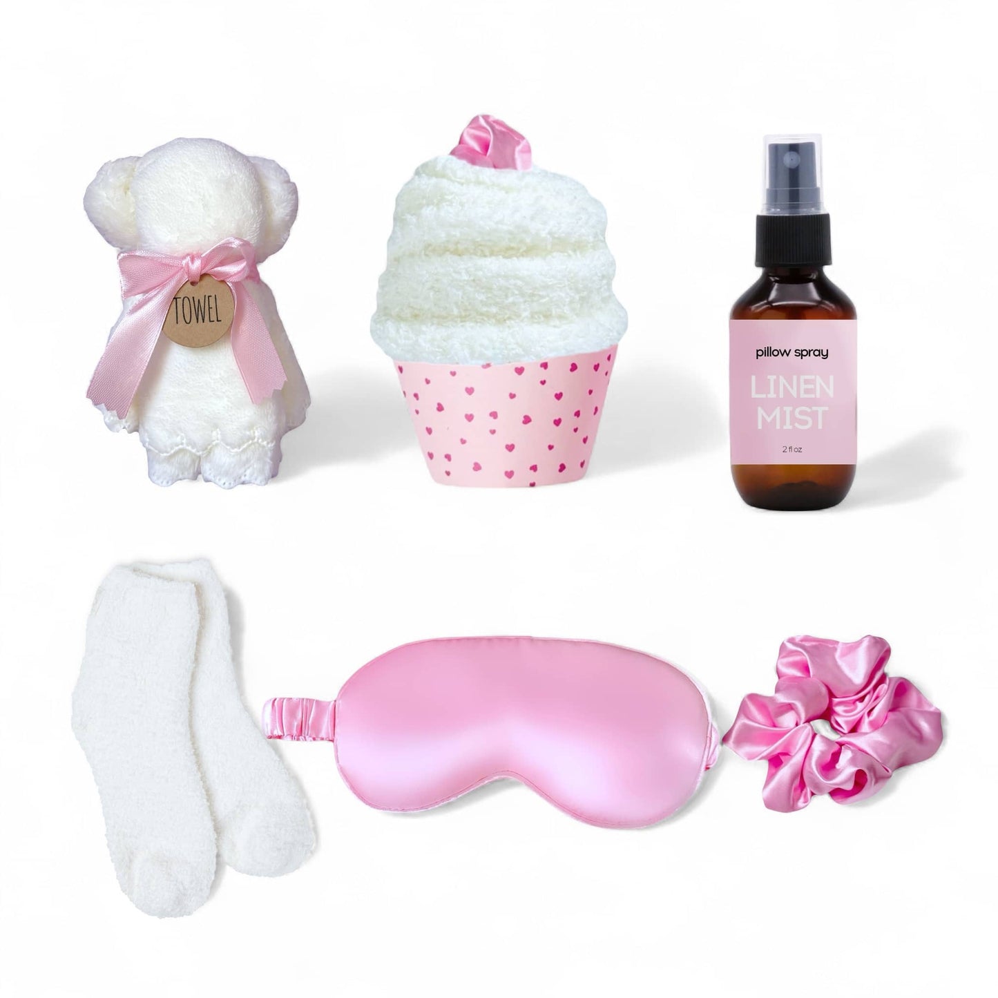 Dabble Doll pink gift box for women featuring a plush towel, sleep mask, cozy socks, and linen mist